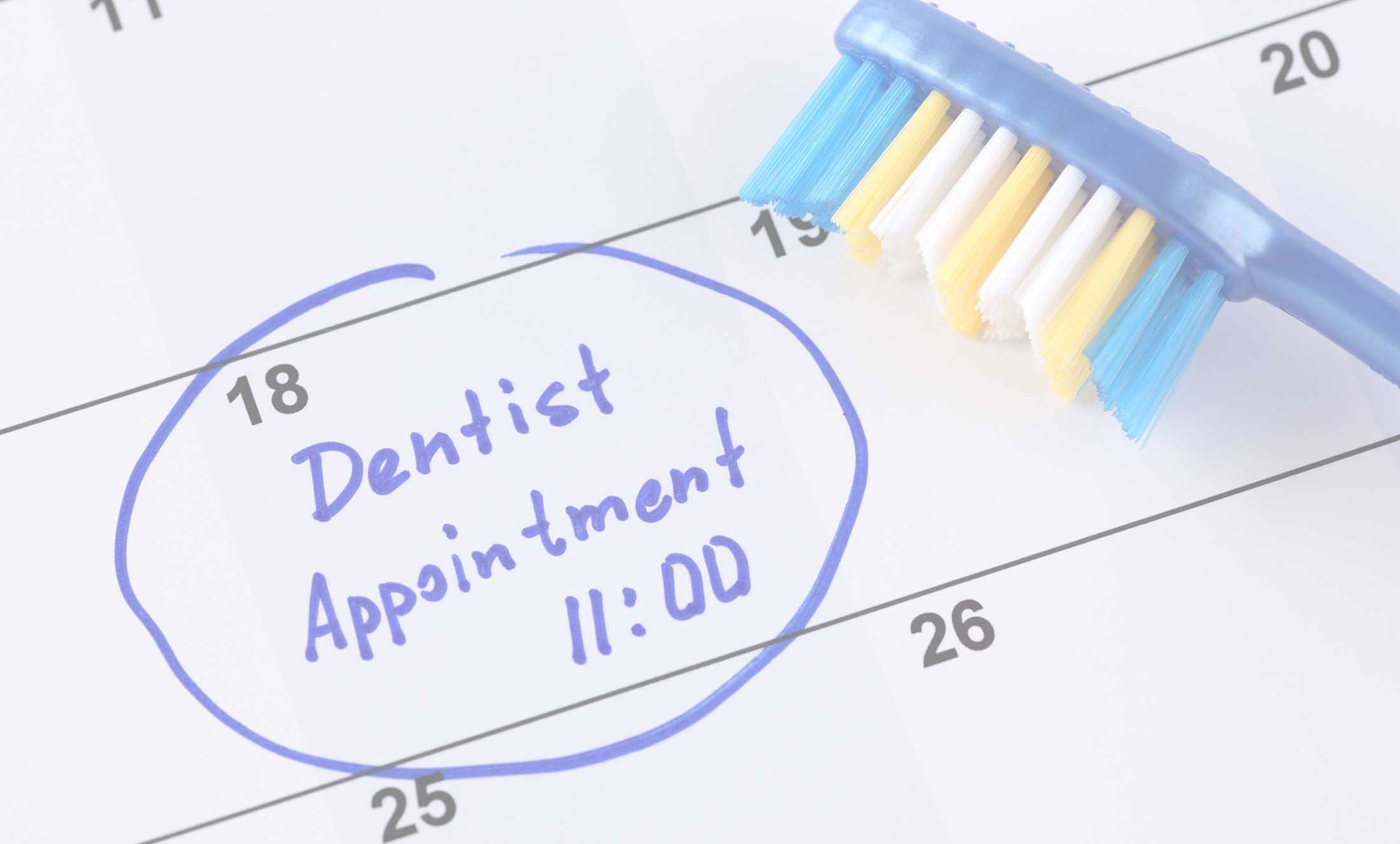 The image shows a calendar with the word 'dentist' circled under an appointment time, accompanied by a blue pen and a toothbrush with bristles pointing upwards.