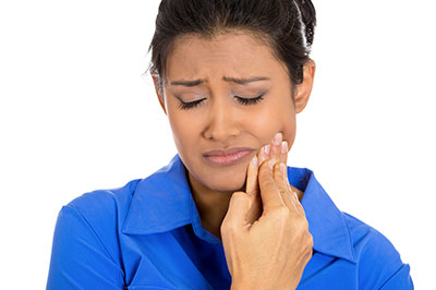 The image shows a woman with her mouth open, looking upwards towards something outside the frame. She appears to be in a state of surprise or concern, and she has a small object in her hand that could be a toothbrush or dental floss.