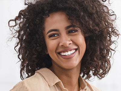 A woman with curly hair smiling at the camera.